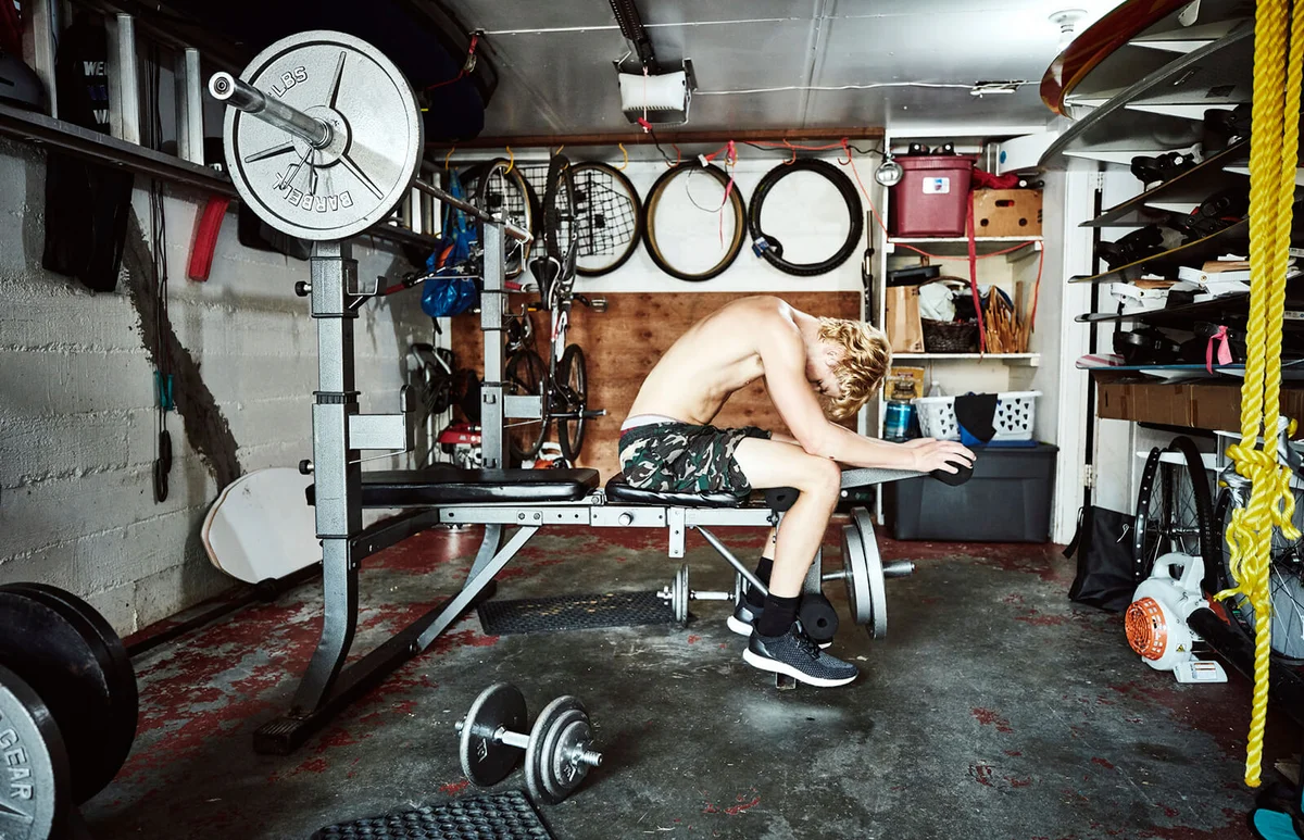 Teen boy working out in basement gym