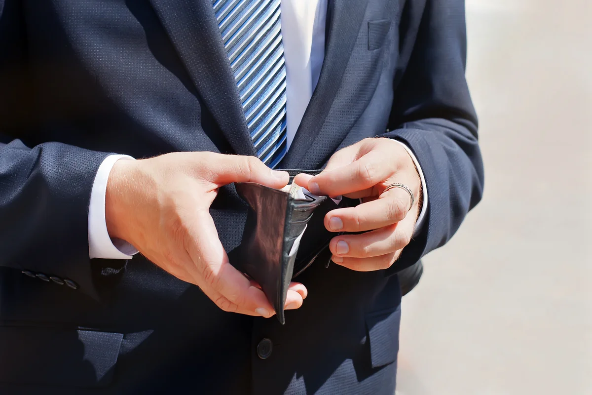 Groom wearing wedding classic suit, holding wallet