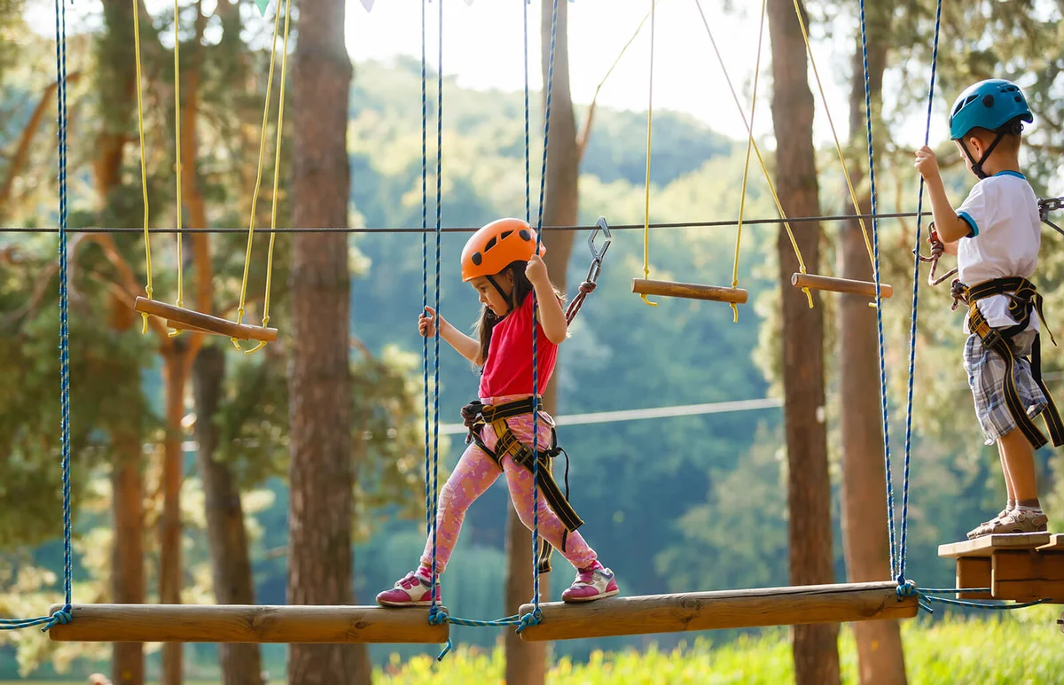 cute little boy and girl walk on a rope bridge