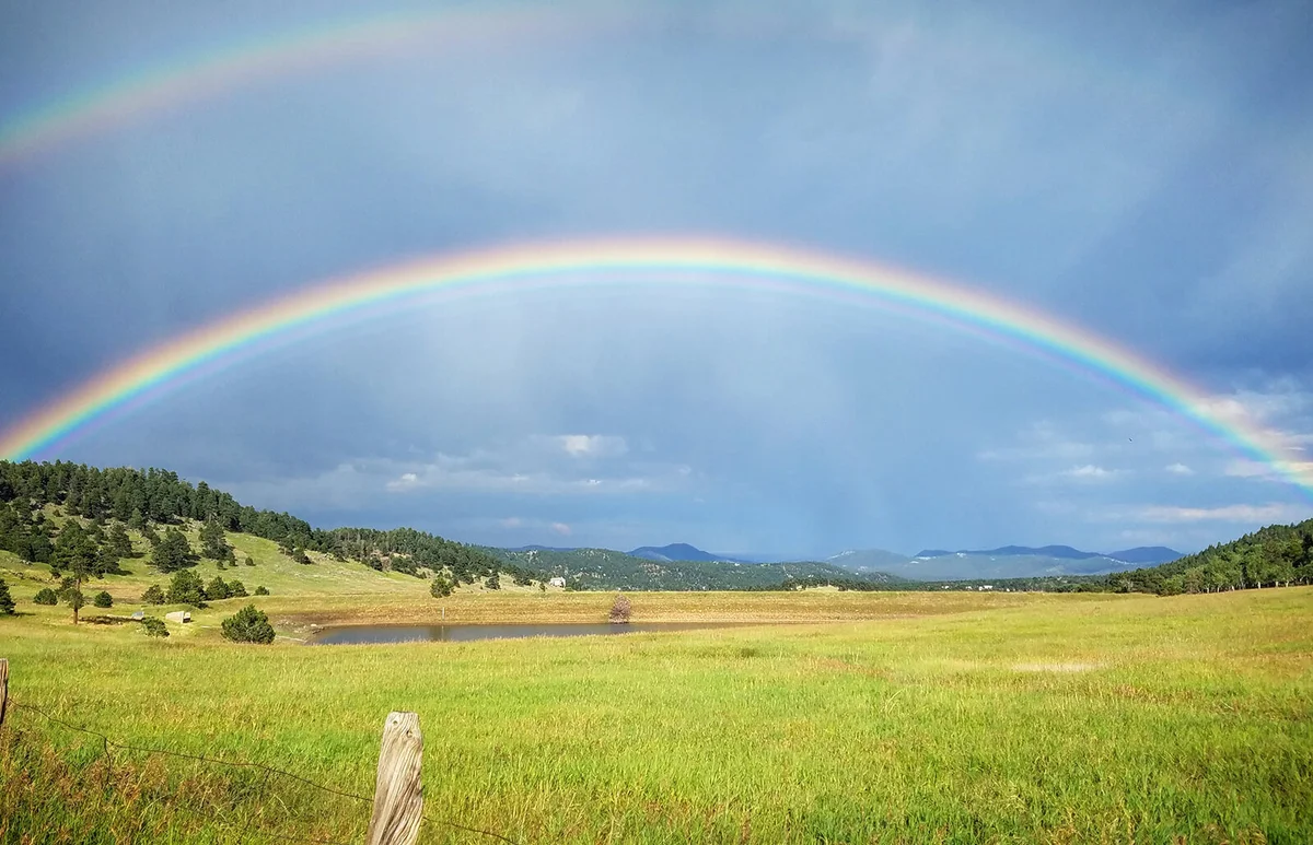 Scenic View Of Rainbow Over Field