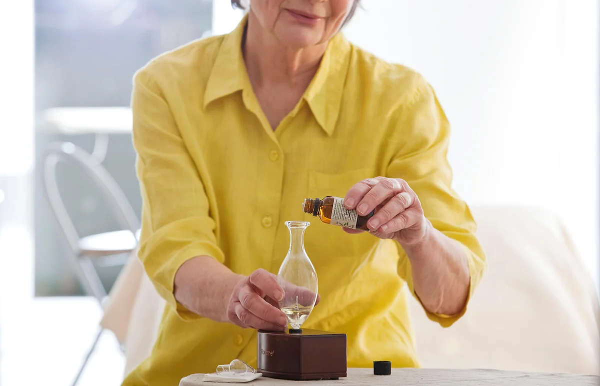 Senior woman using essential oil diffuser