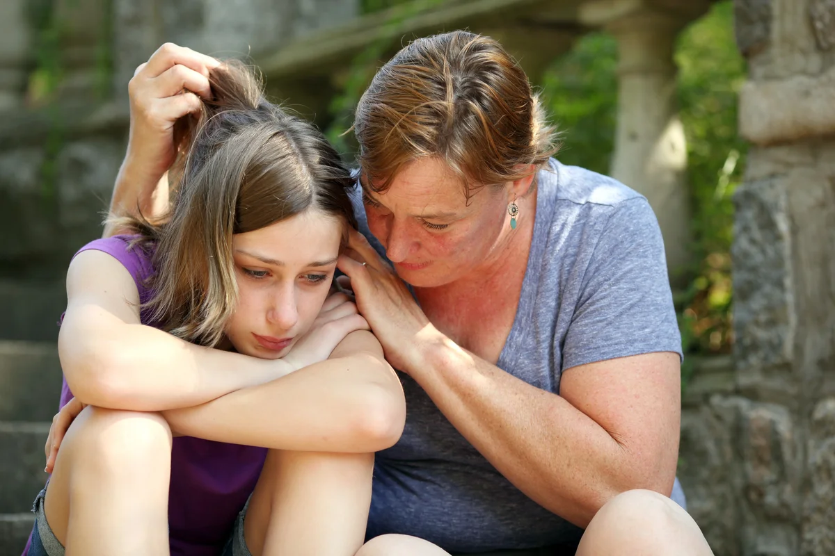 Woman hugging teen girl