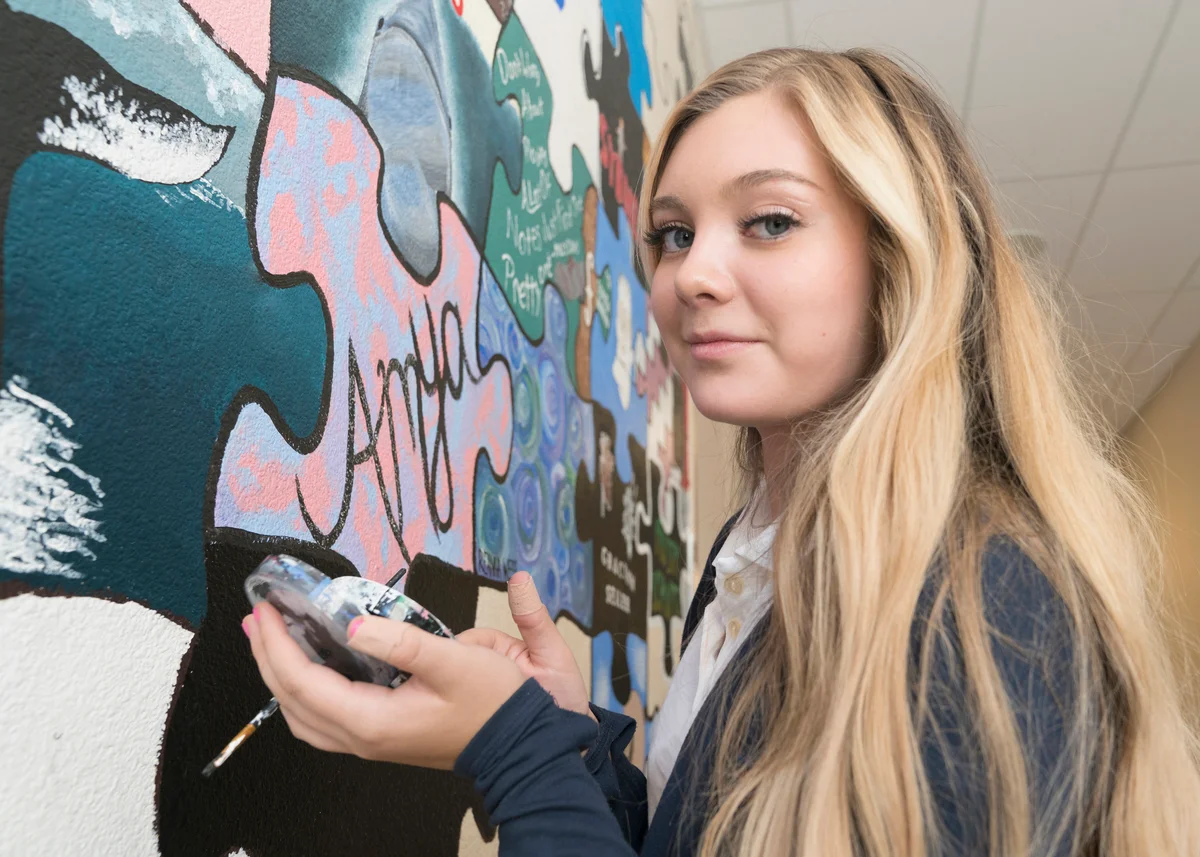 Teen girl painting a wall