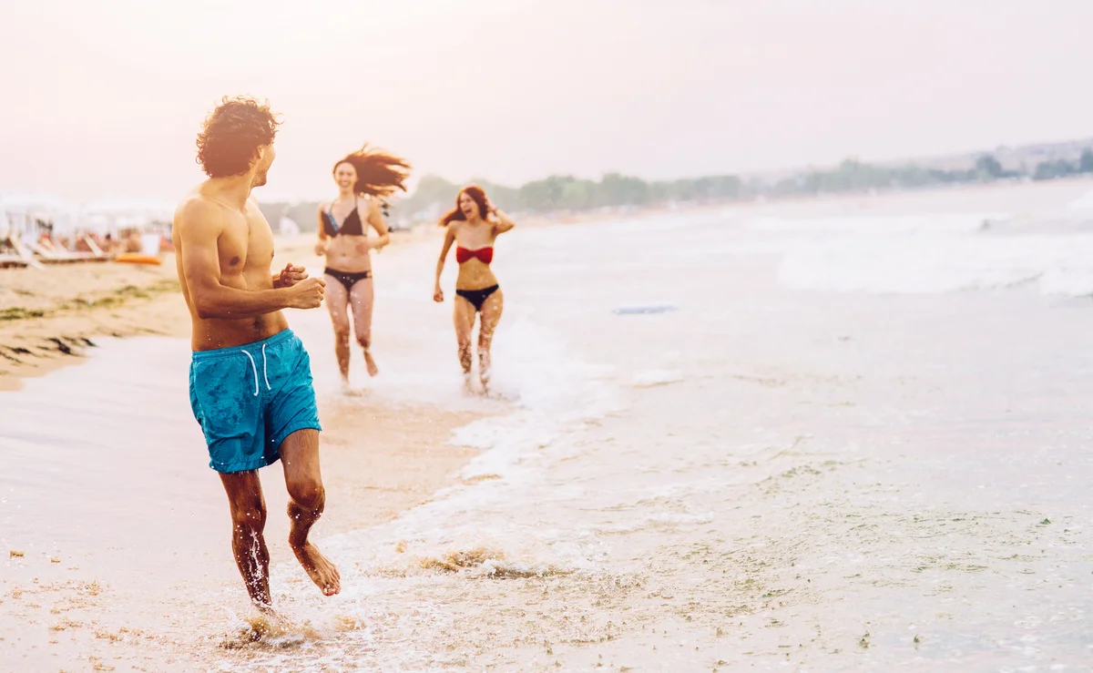 Two women chasing a man