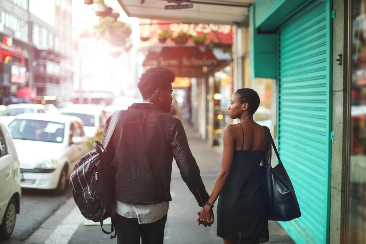 Couple holding hands on busy street