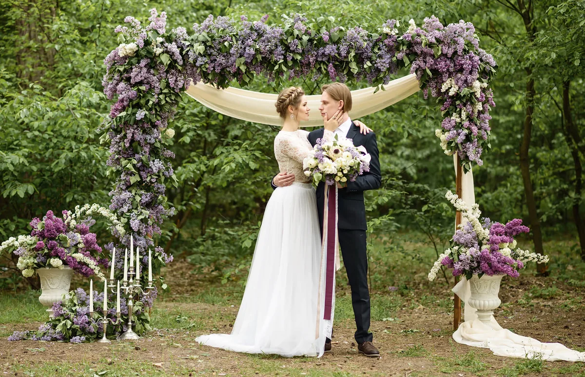 Bride and groom near the arch of lilac