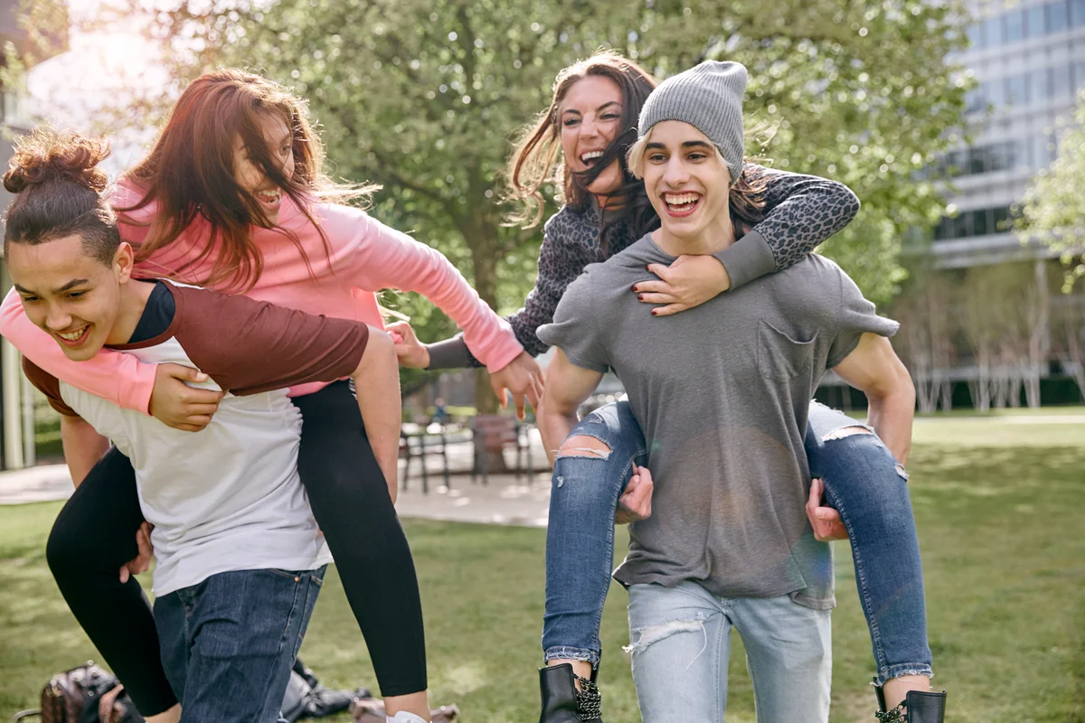 Teen couples playing piggyback