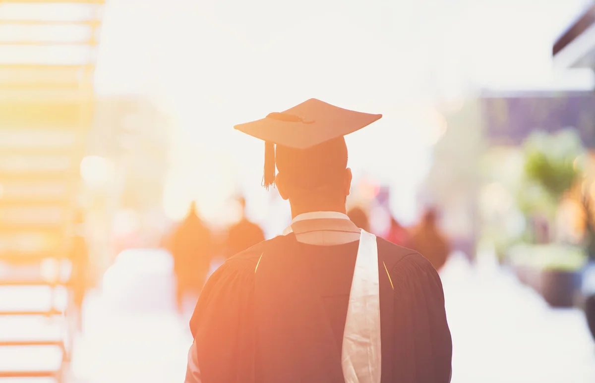 Fresh graduate walking away in street