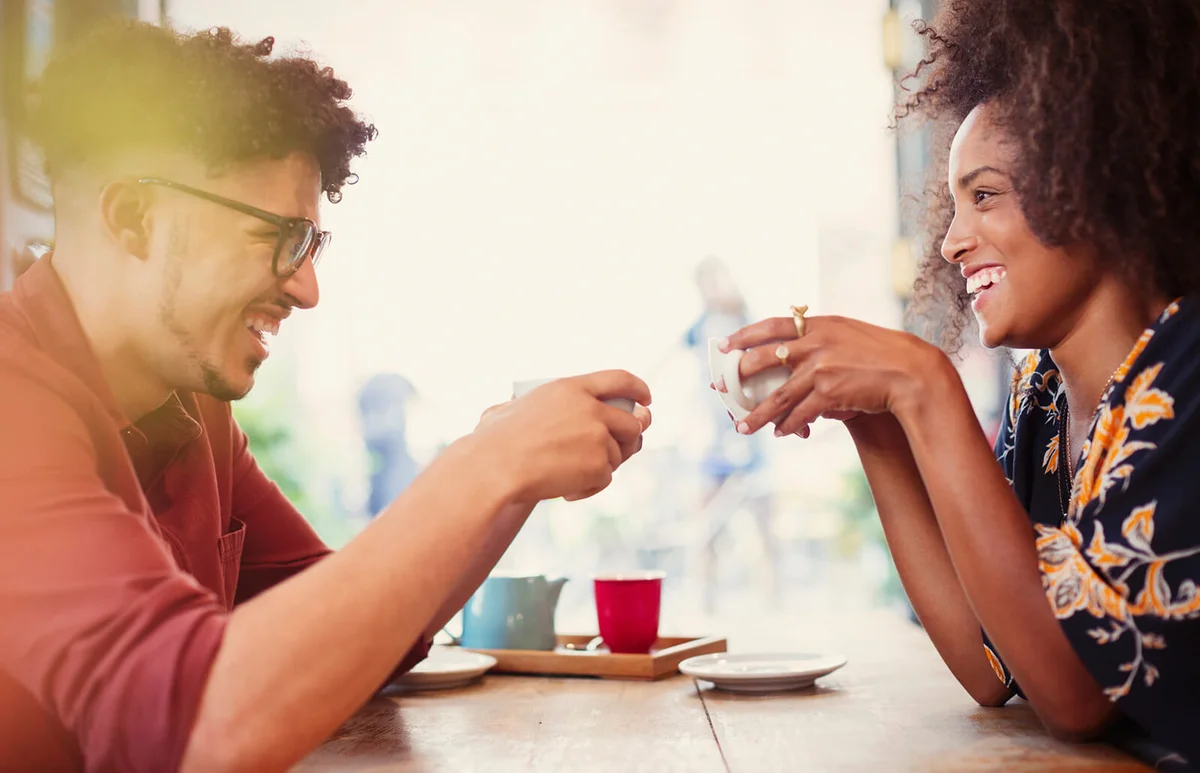 Couple drinking coffee face to face in cafe
