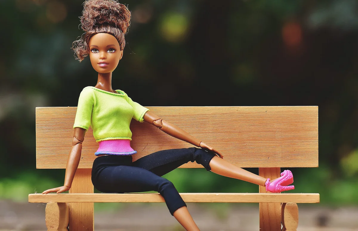 Doll Sitting on Brown Wooden Bench