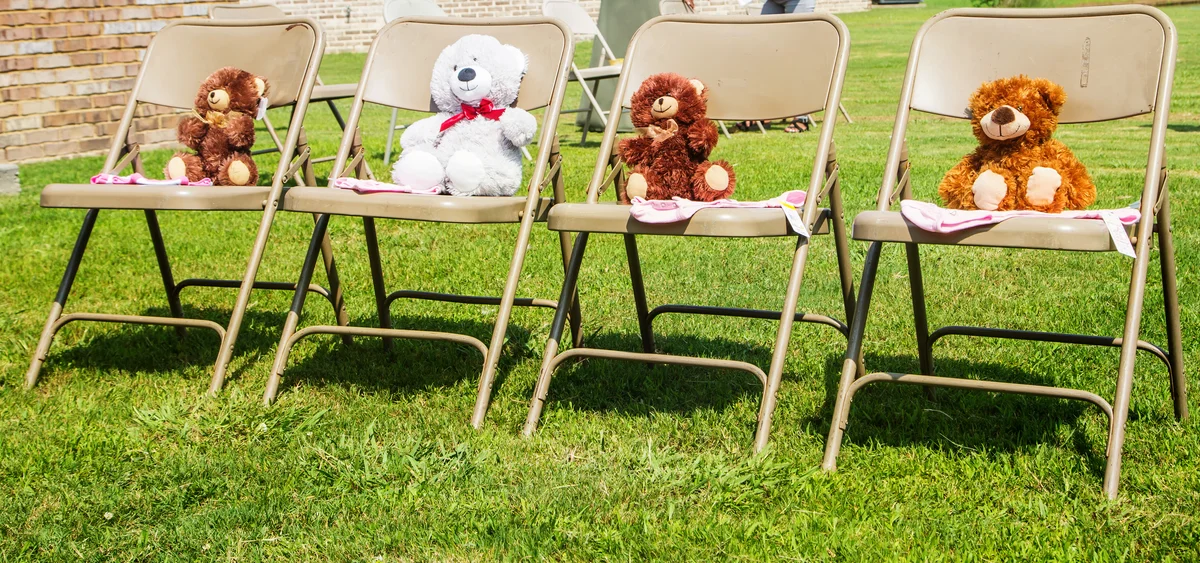 Four seated Teddy Bears lined up at a baby shower