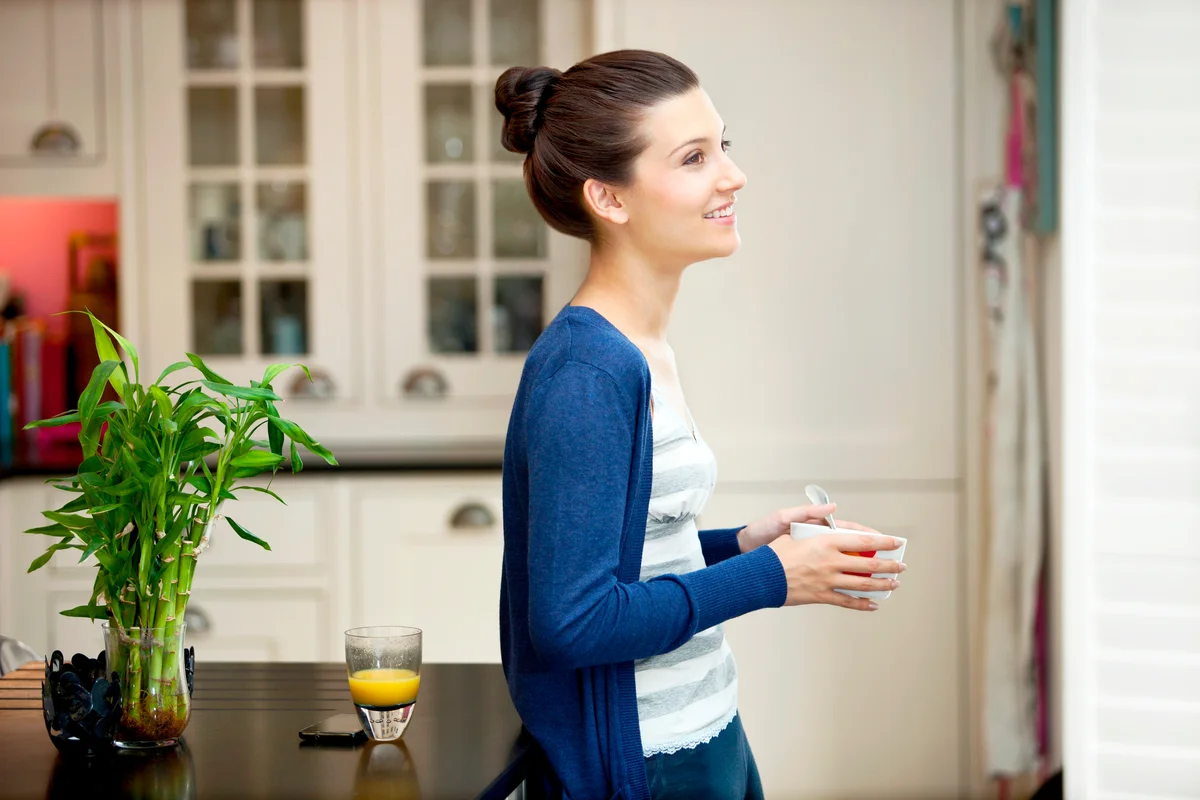 Young woman eating breakfast in her kitchen