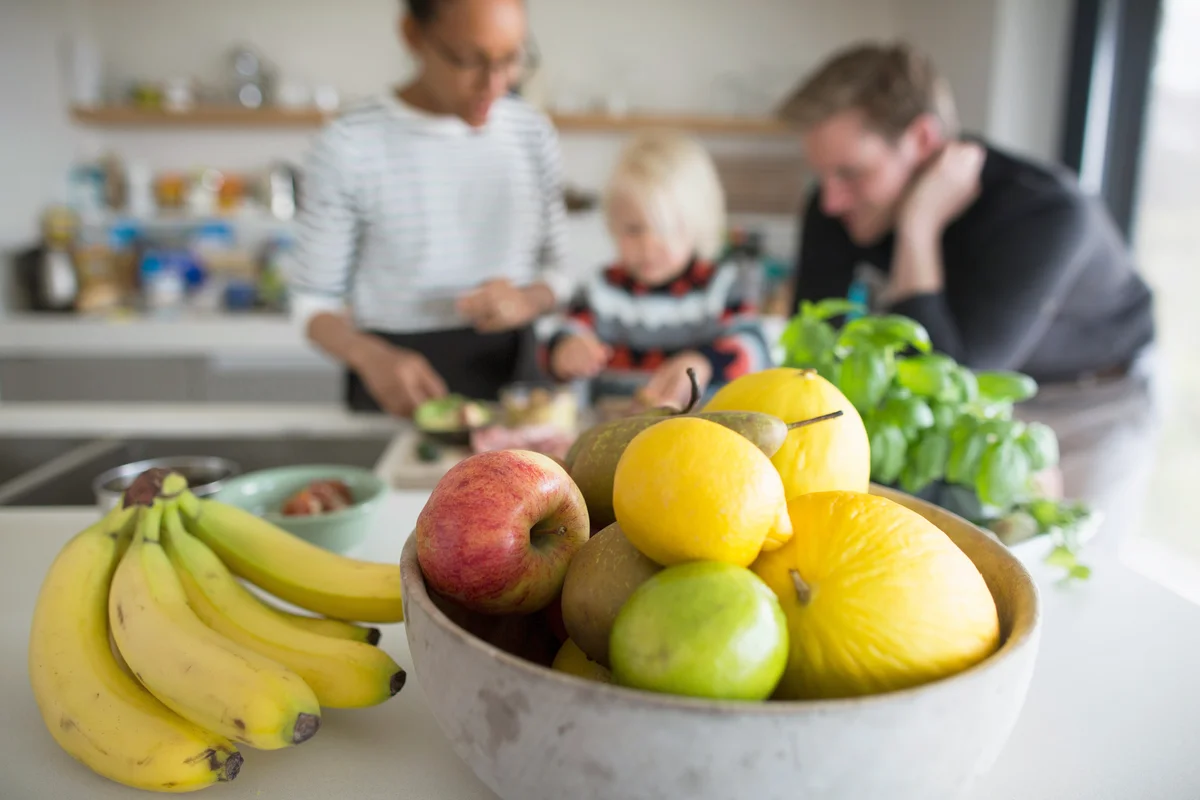 Fruit bowl with fresh fruit and family cooking