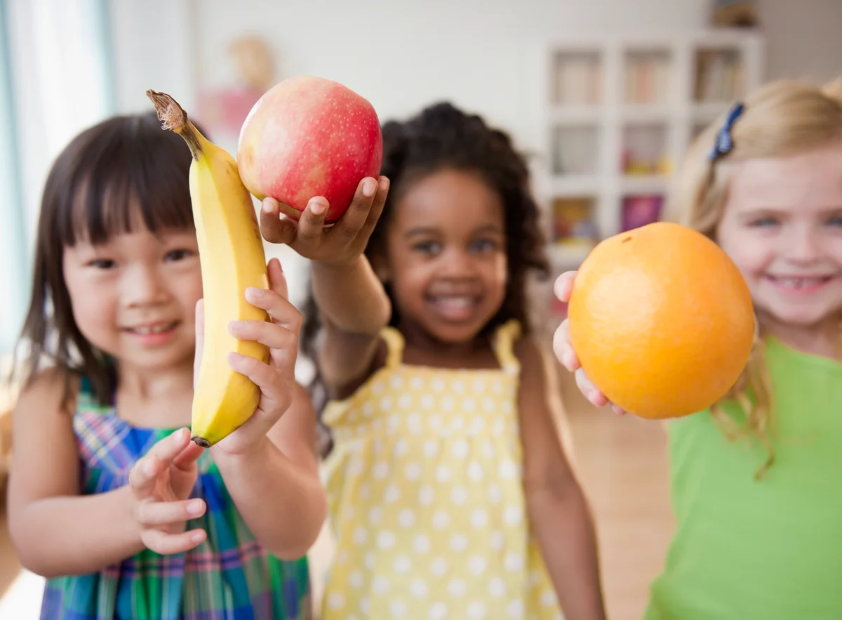 Children holding out fresh fruit