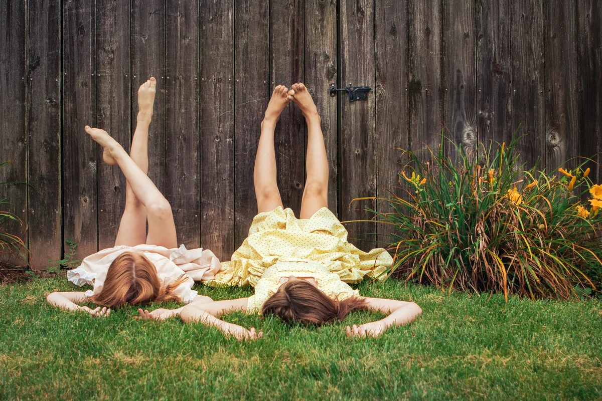 Two sisters lying on the grass