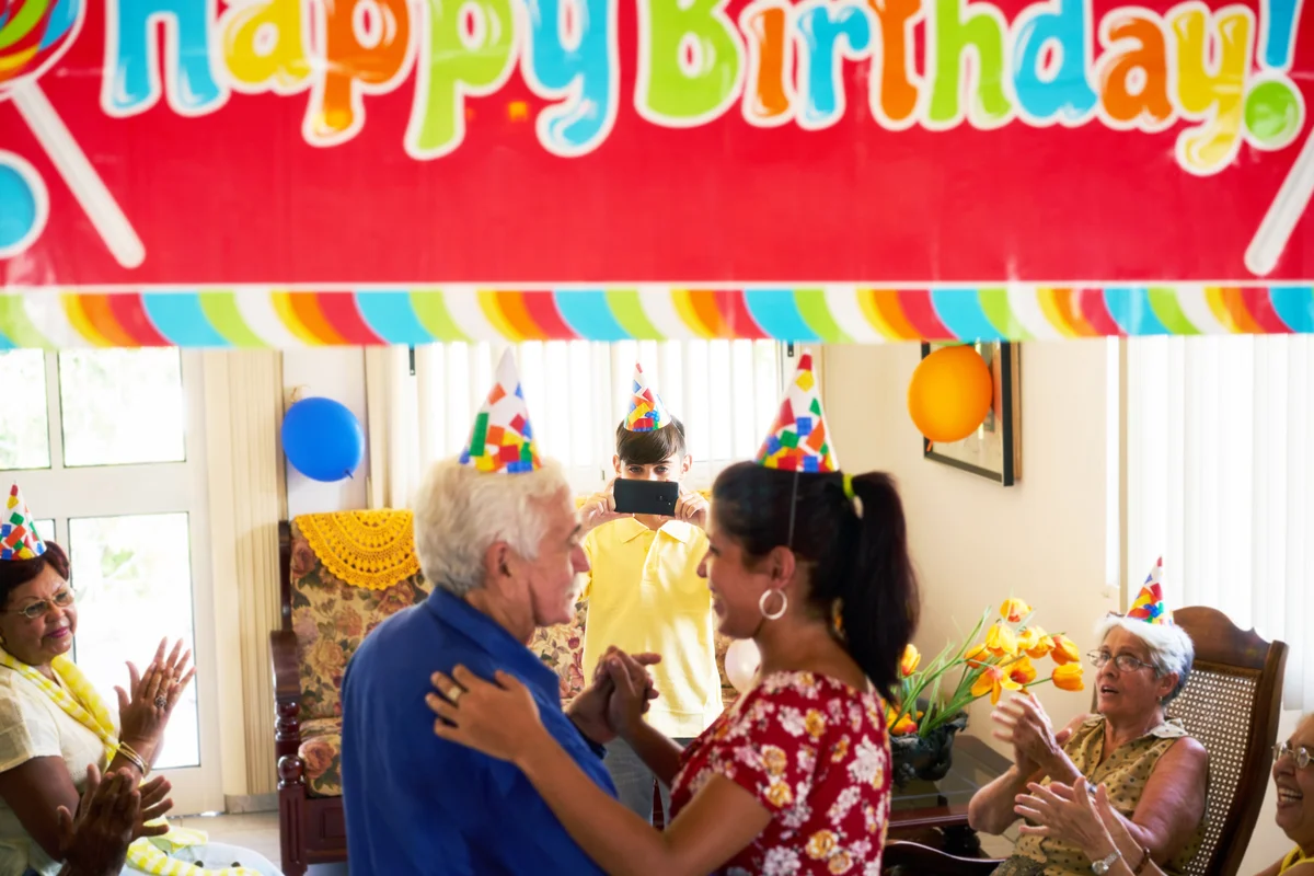 Family celebrating senior man birthday in nursing home
