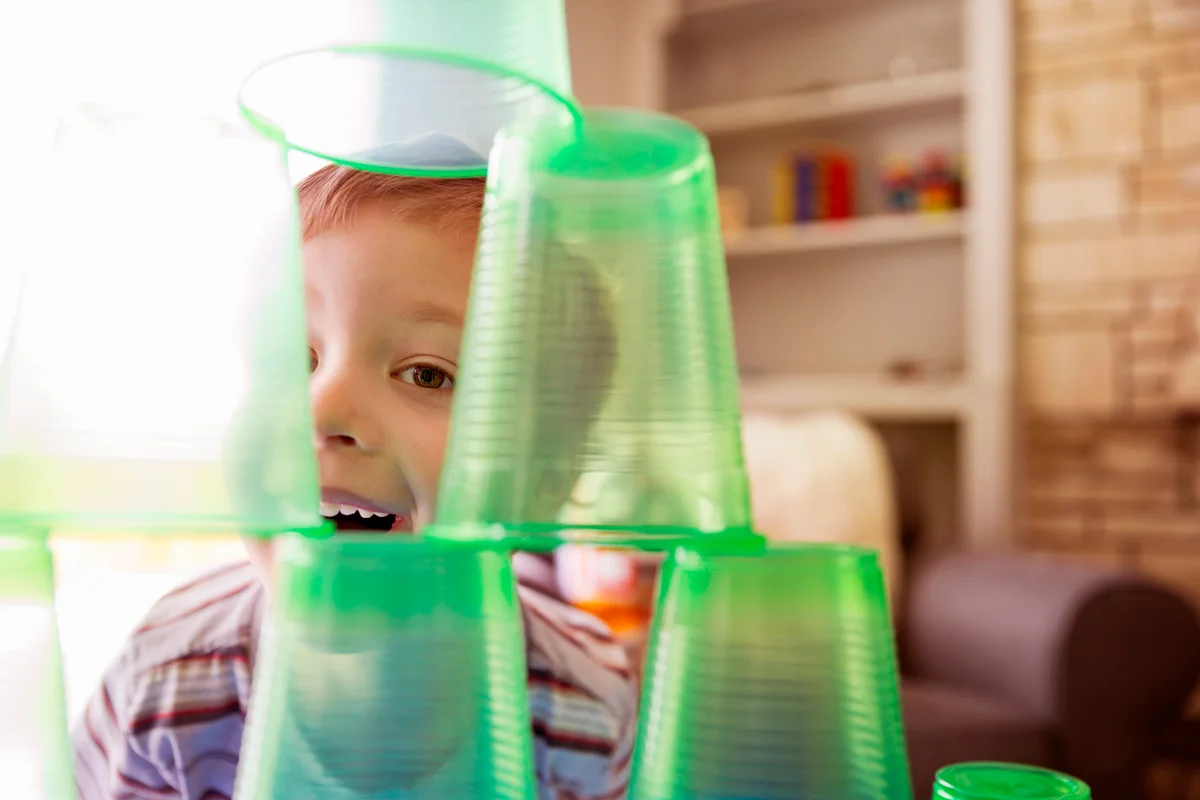 Smiling boy playing with plastic cups