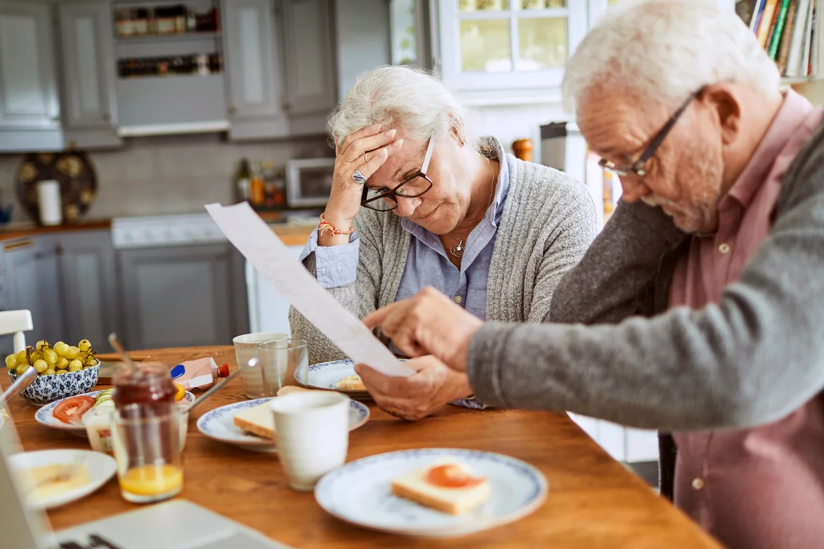 Senior couple having breakfast and doing bills