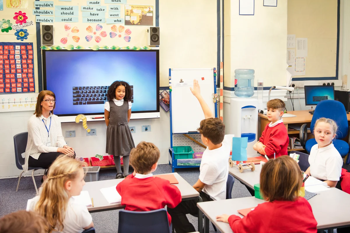 An elementary schoolgirl presents her work to the class