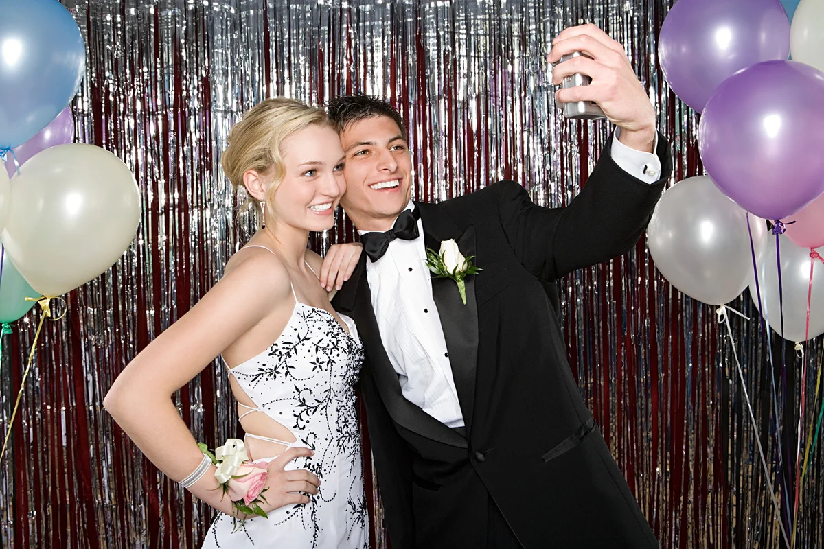 Couple posing in front of silver streamers