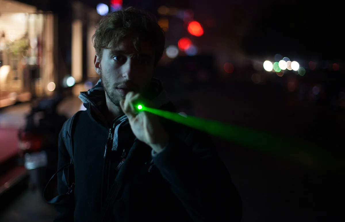 Teen boy holding a laser pointer