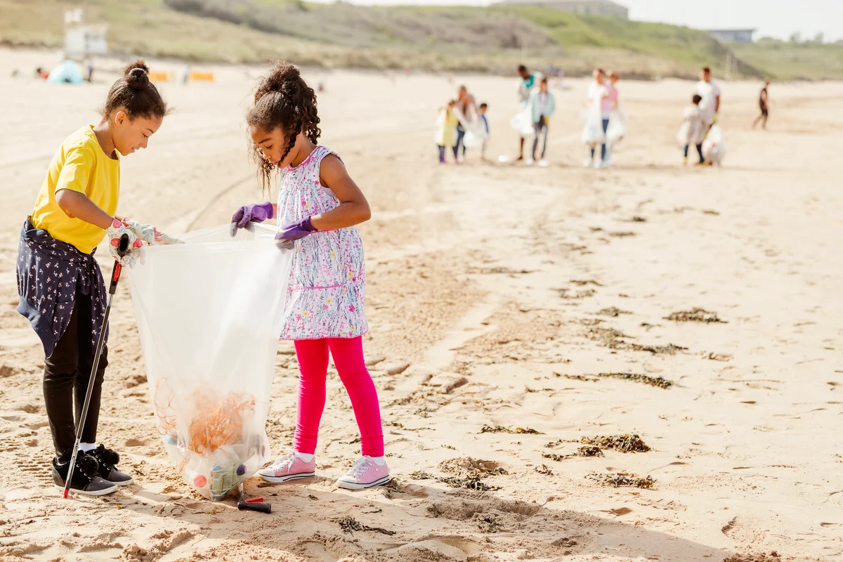 Young Girls Collecting Plastics and Rubbish Off a Beach