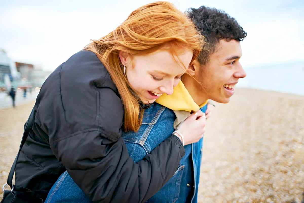 Young couple enjoying moment together at the beach in winter