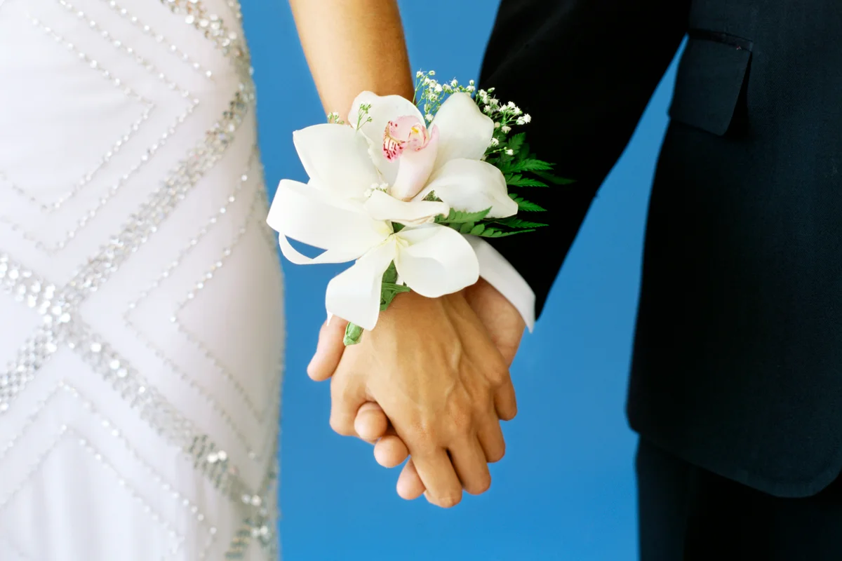 Teenage couple holding hands in a prom
