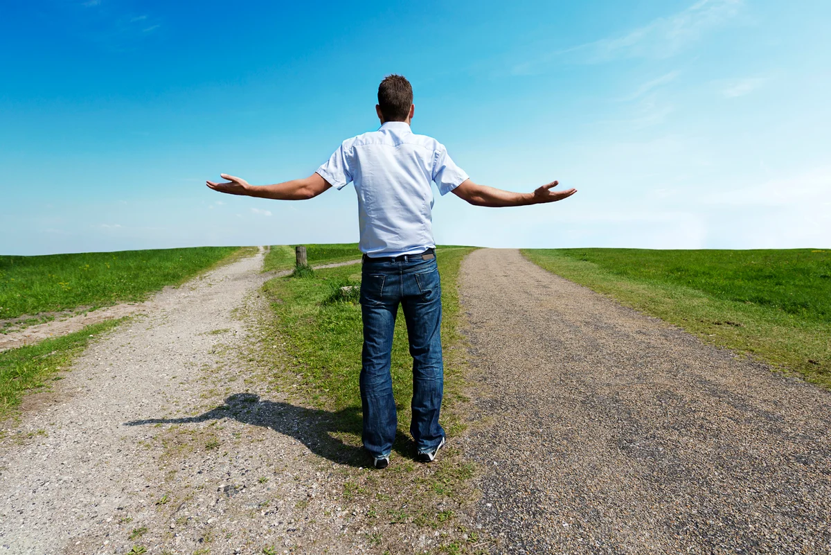 Man standing at a fork in the road