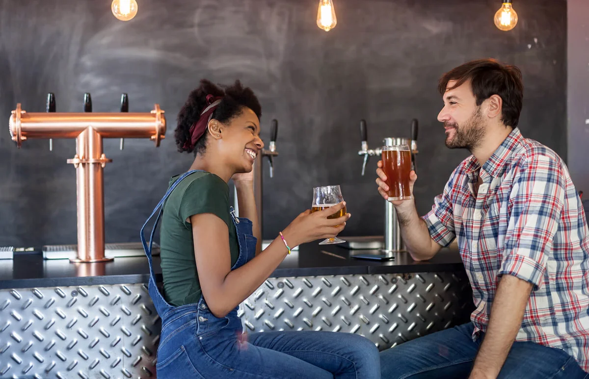Couple talking and drinking beer in a bar