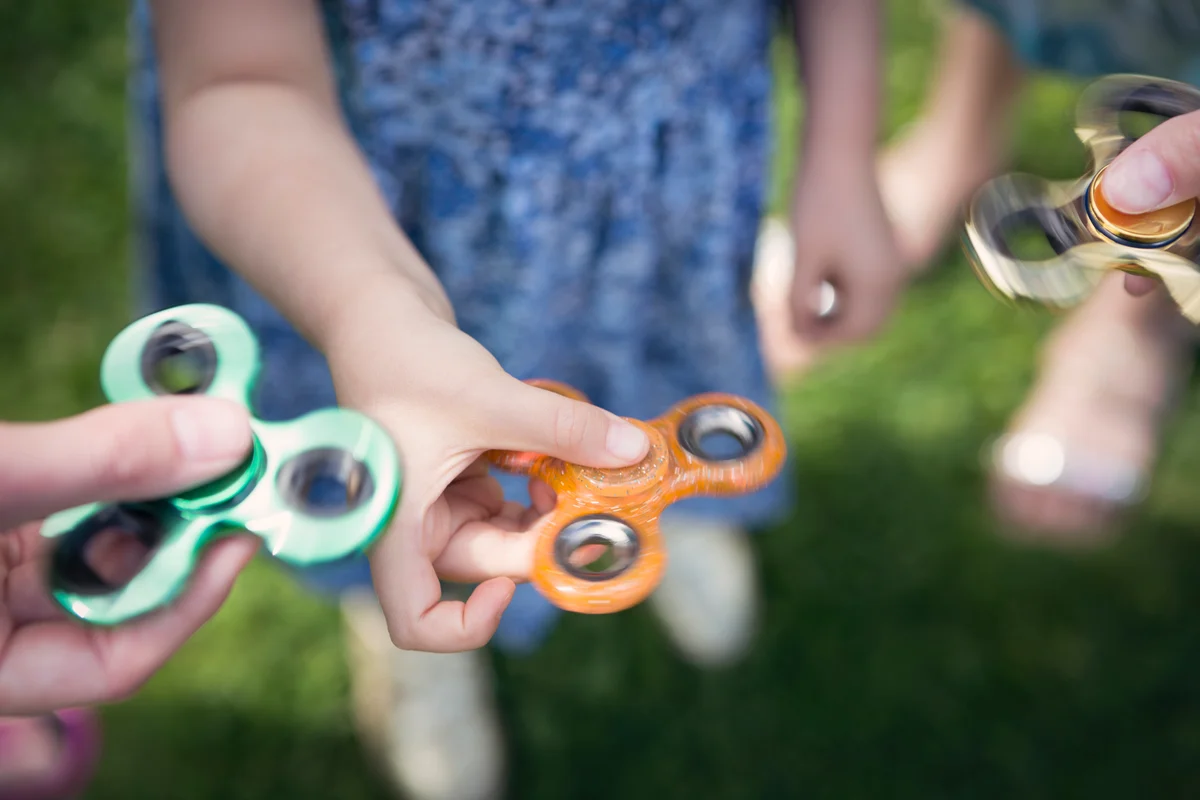 Hands holding fidget spinners