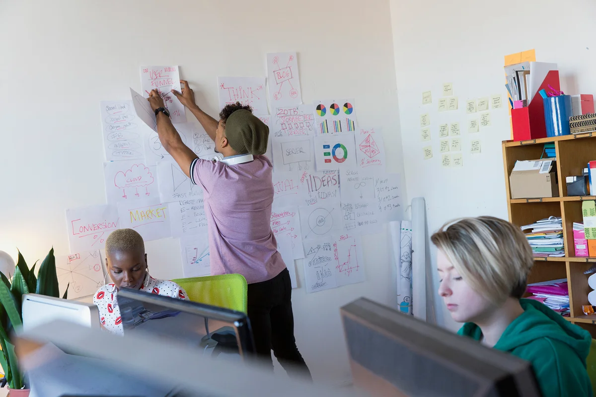Teen pinning up market research to analyze