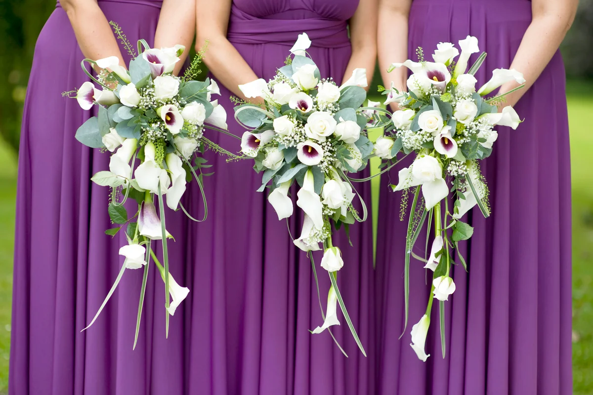 Three bridesmaids holding wedding bouquets