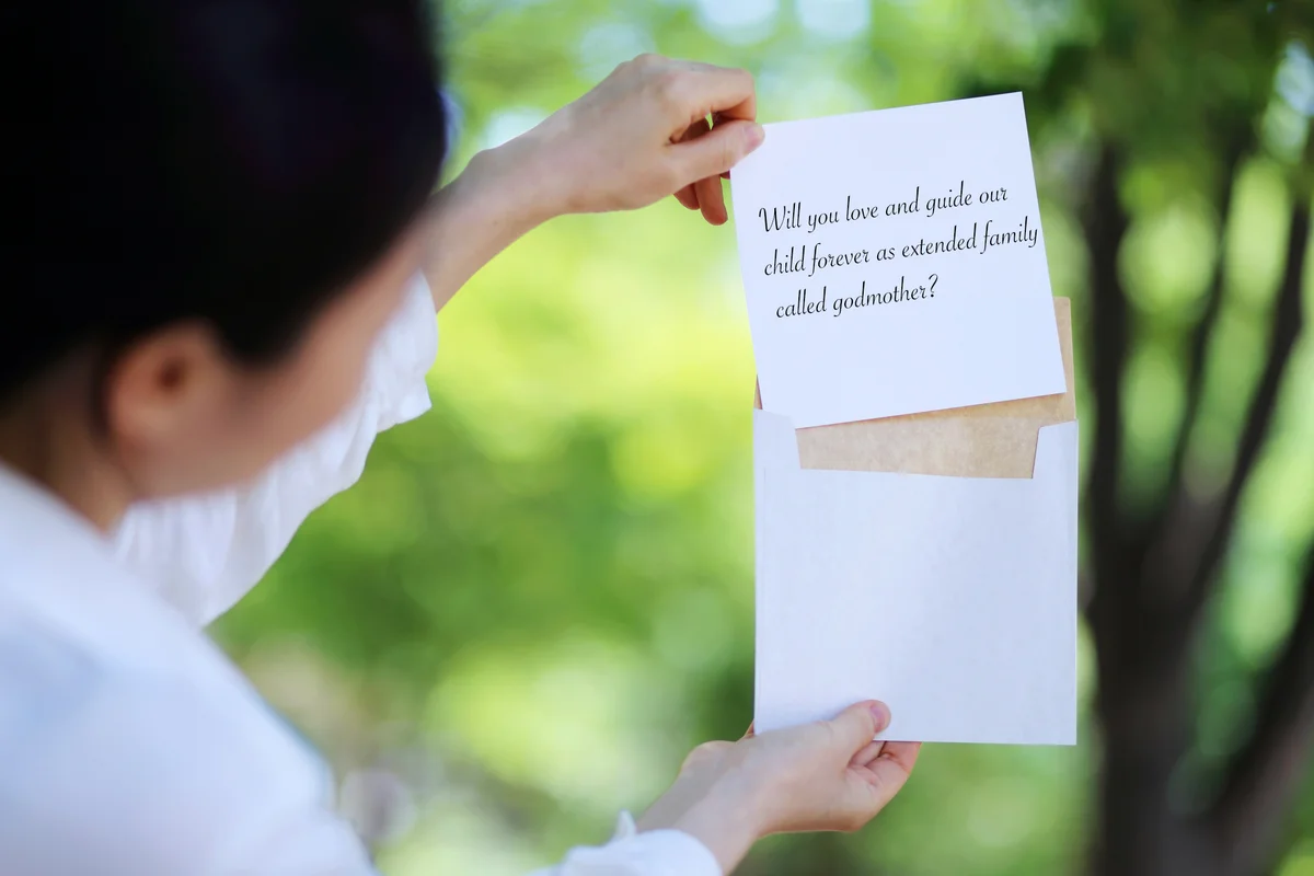 Woman's Hand Pulling White Card From Envelope