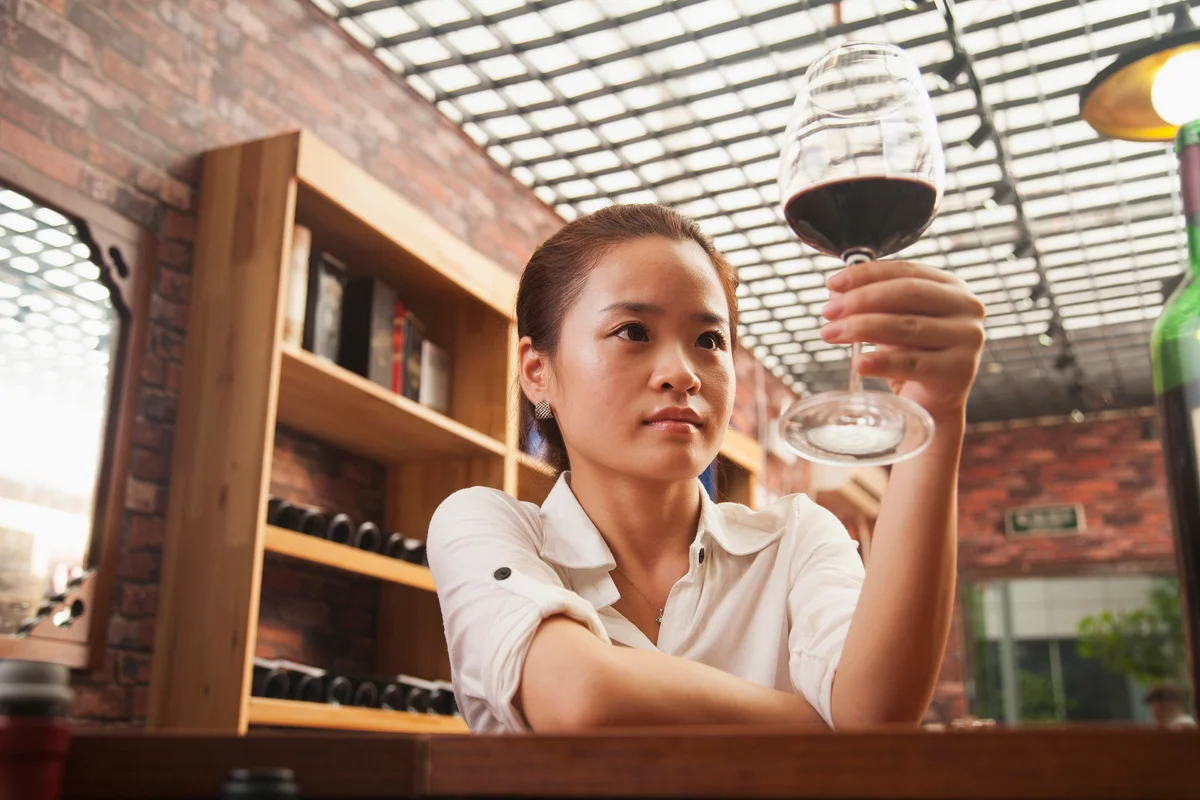 Woman looking at red wine