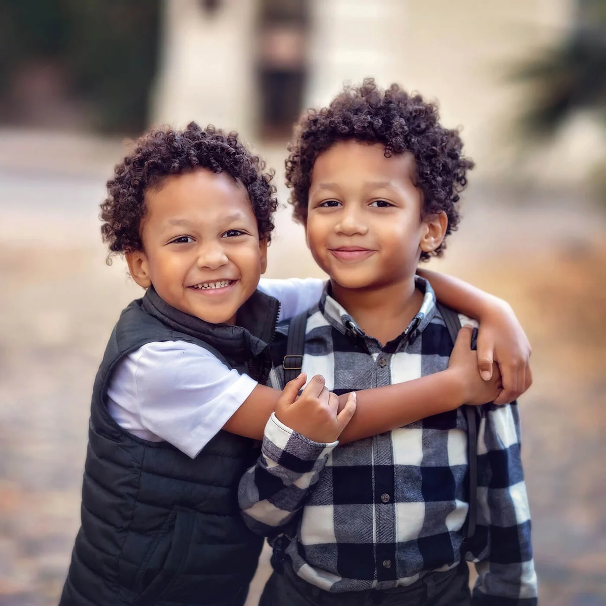 handsome l twin brothers hugging and standing in an urban scene