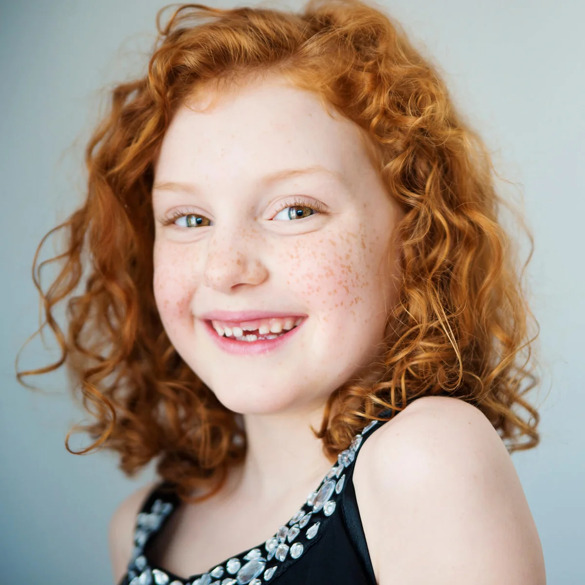 Smiling redhead little girl with freckles and missing tooth
