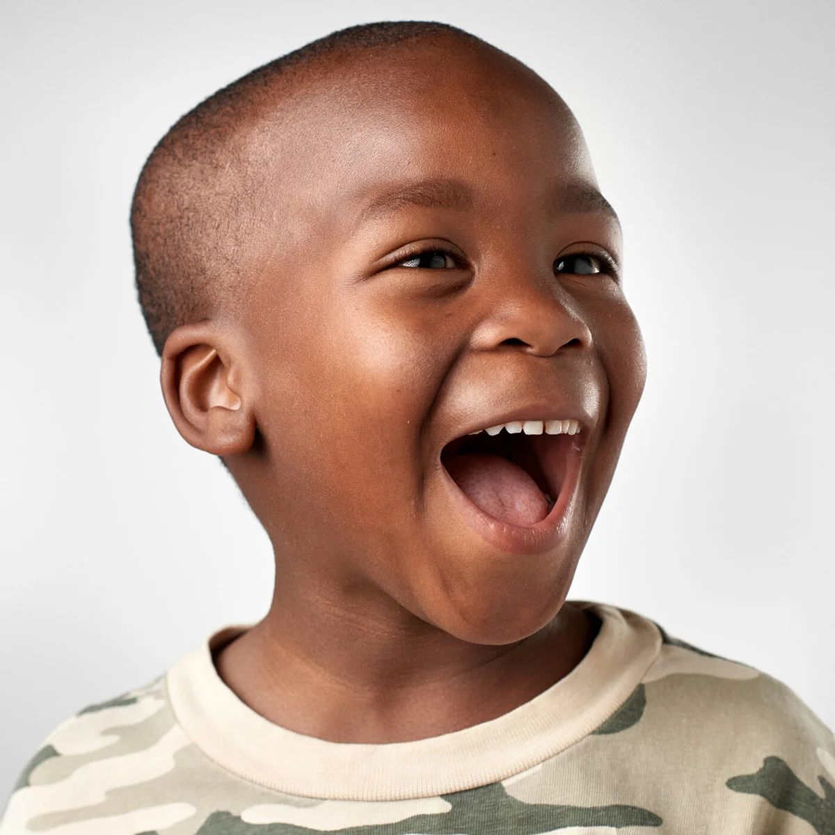 Studio portrait of cute african boy laughing