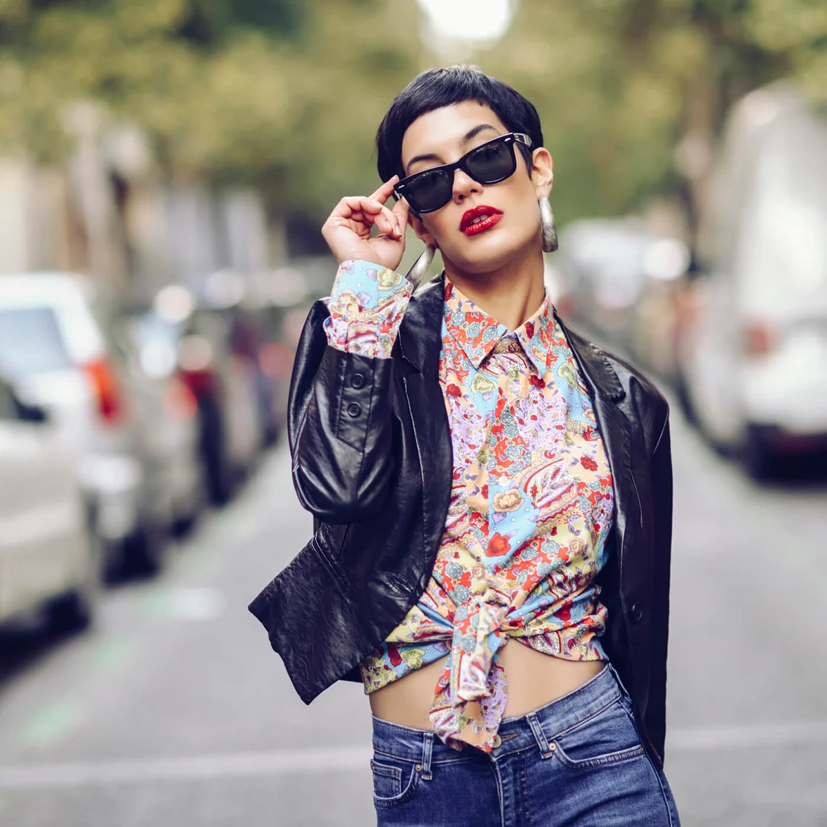 fashionable young woman wearing sunglasses and leather jacket
