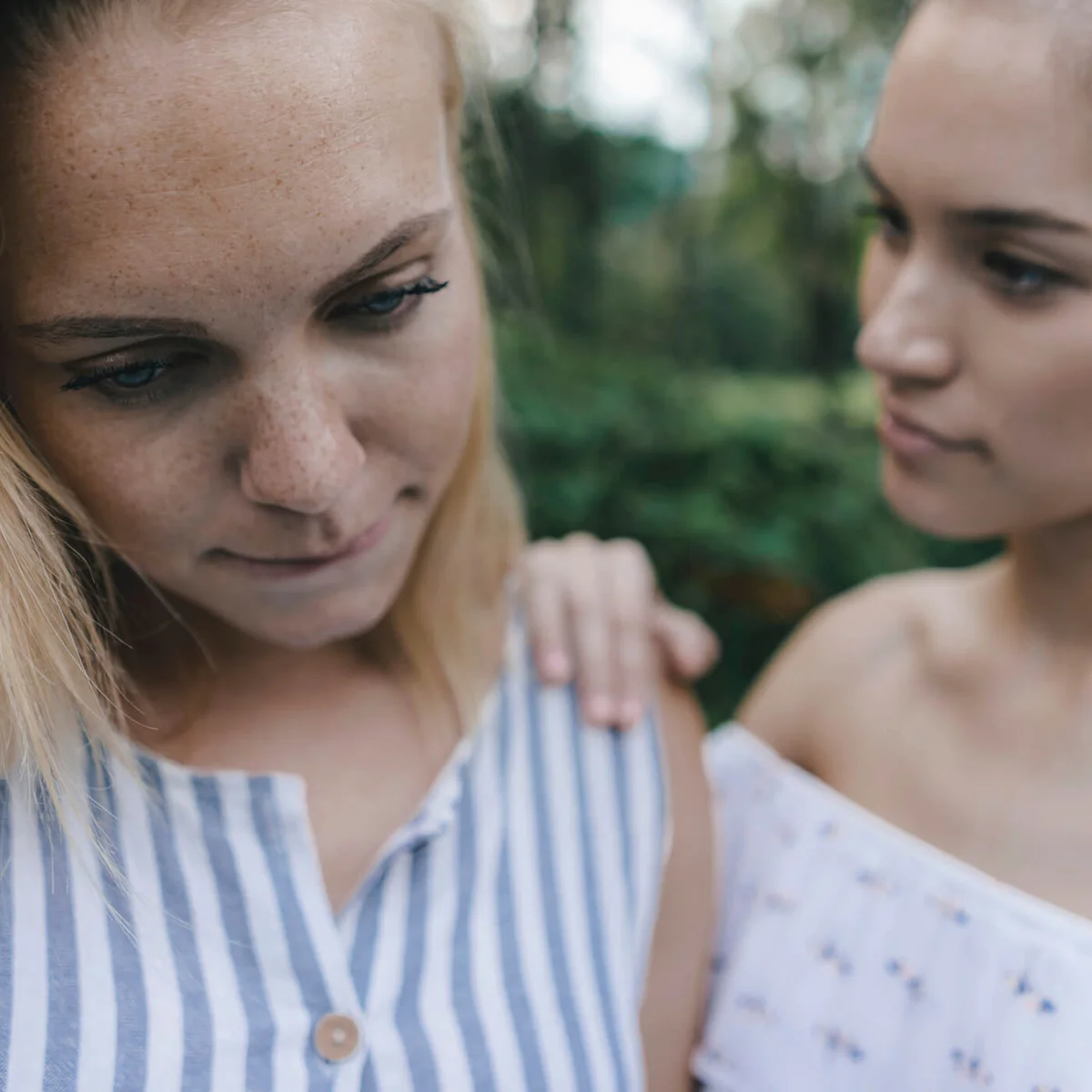 Young woman comforting sad female friend