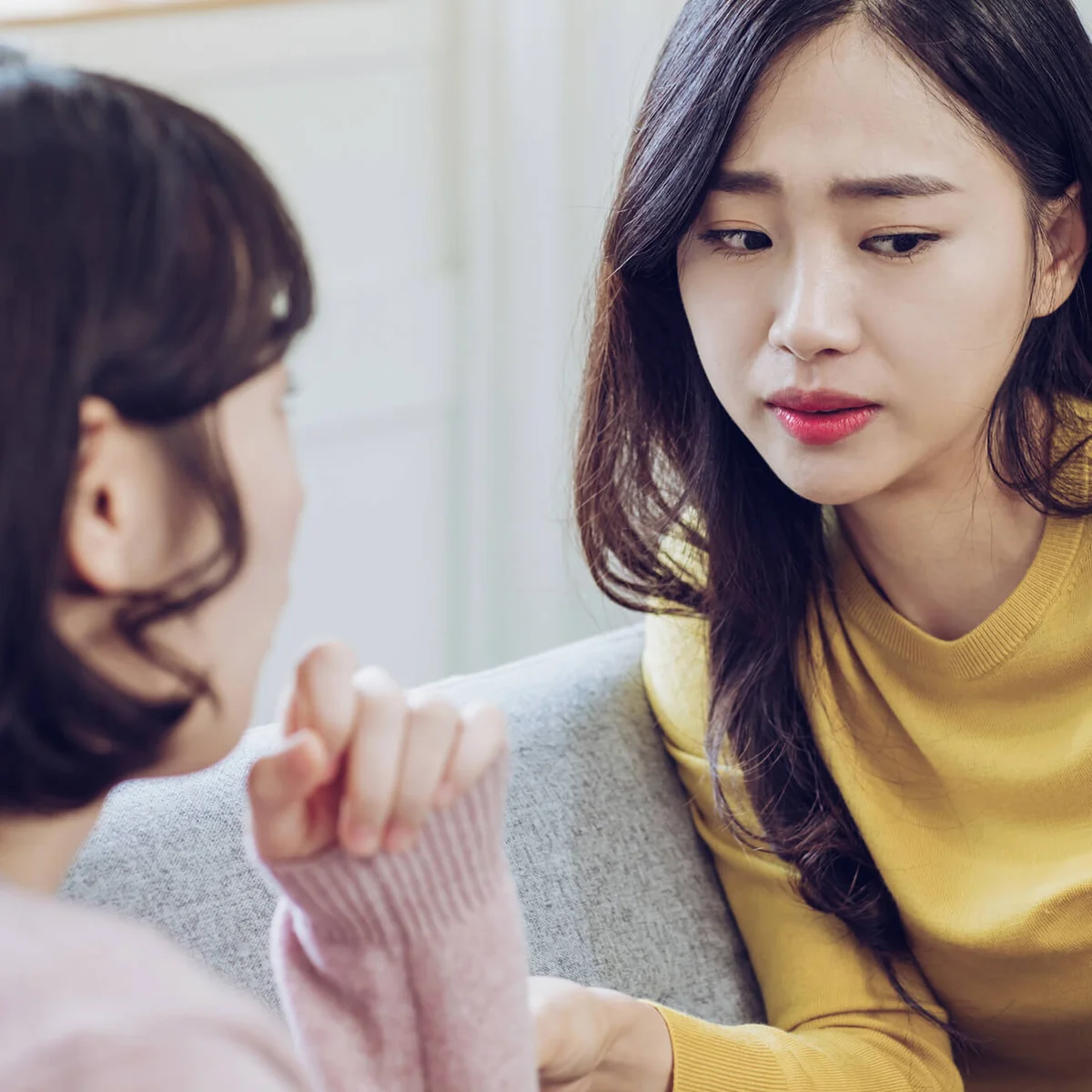 Two Women Talking Seriously on Sofa