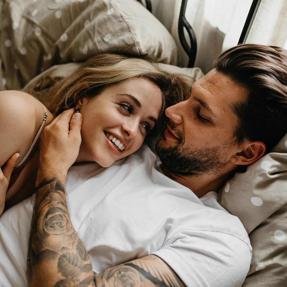 High Angle View Of Loving Young Couple Lying On Bed At Home