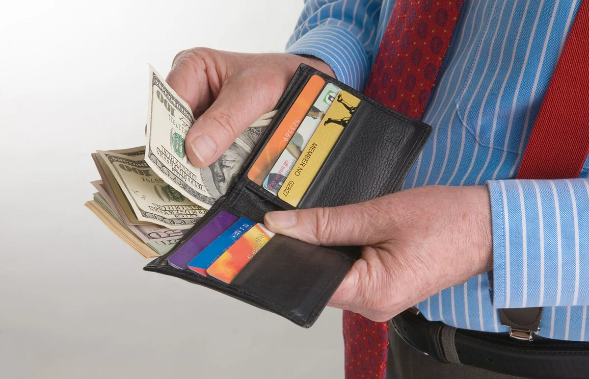 Man with wallet full of dollars