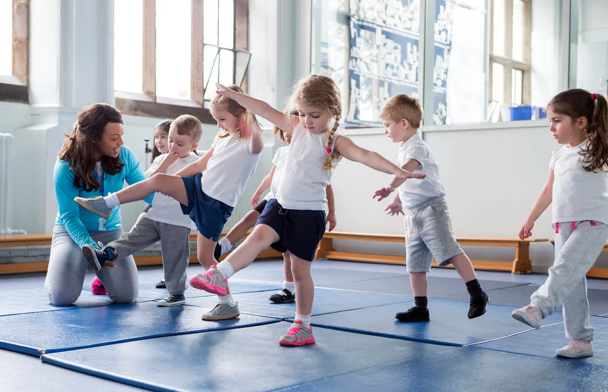teacher helping one of her students during a physical education lesson