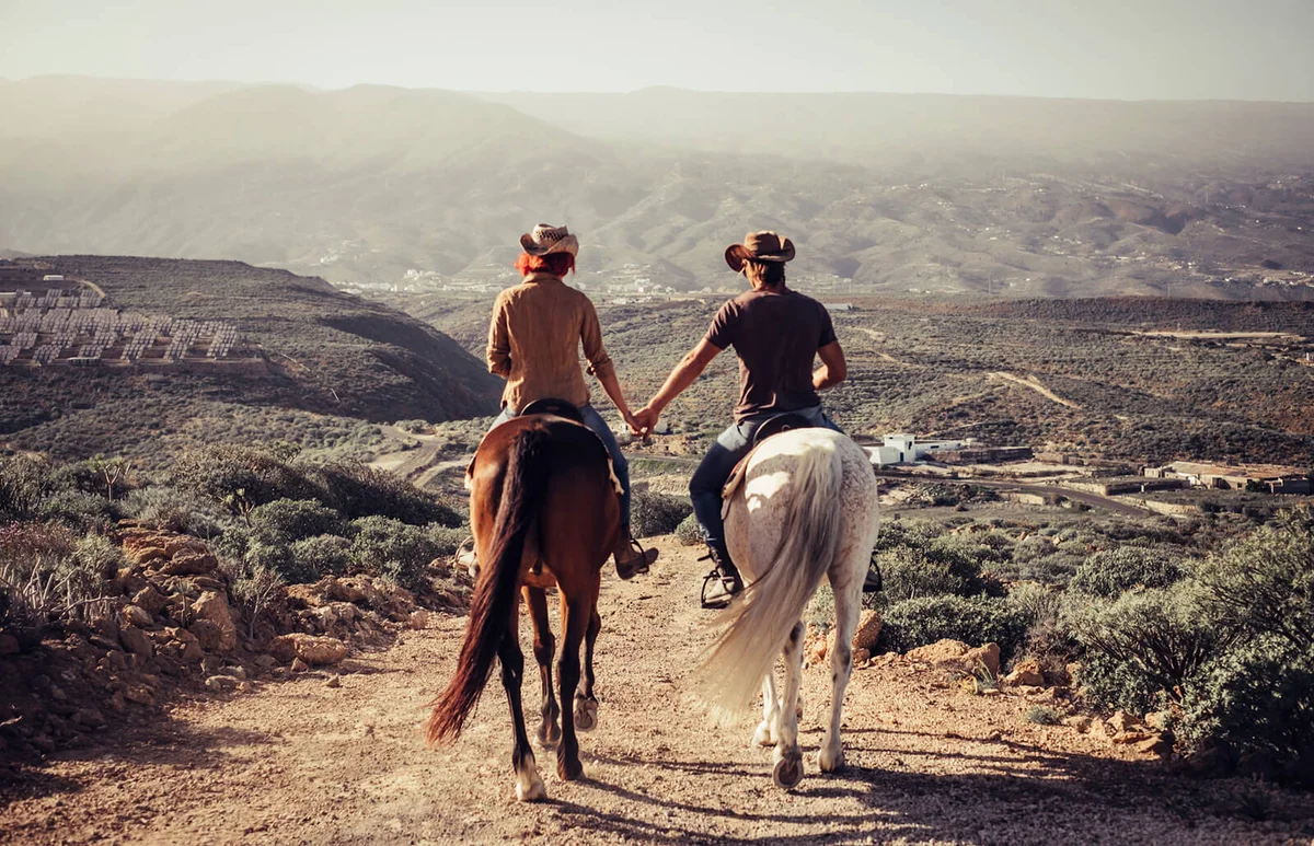 Couple Riding Horses On Dirt Road