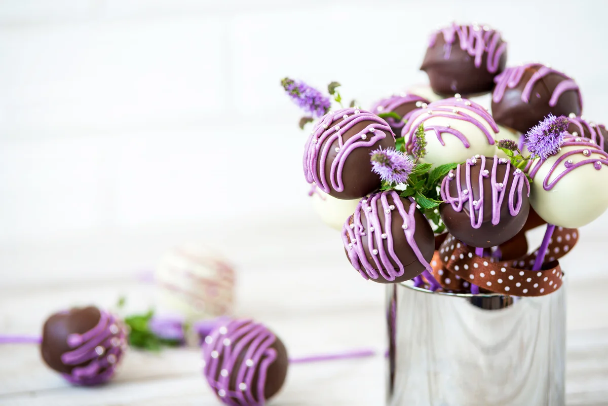 Colorful cake pops on a white wall background
