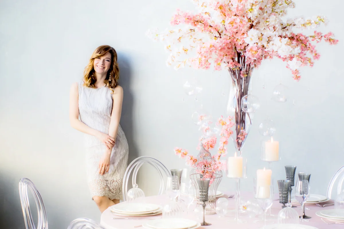 Smiling bride near the wall and wedding decorations