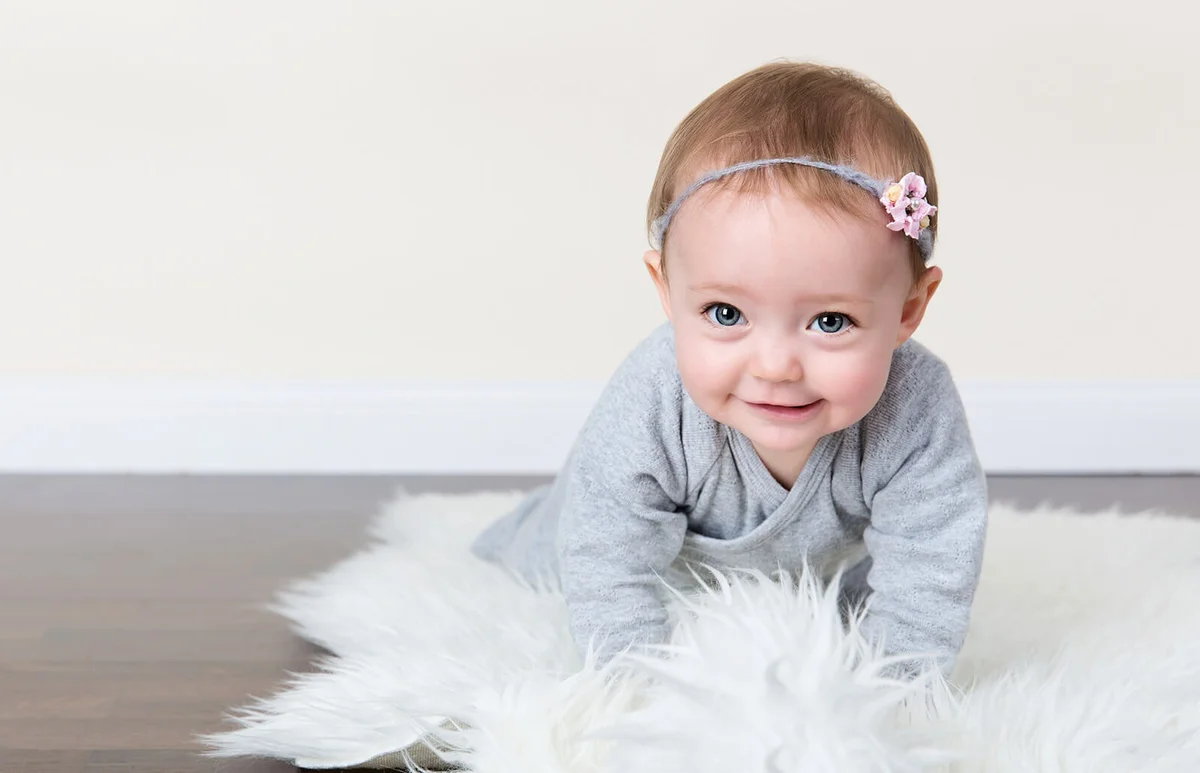 Baby wearing grey in crawling position