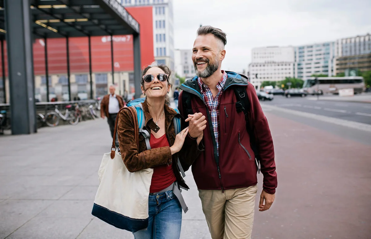 Couple Hold Hands As They Walk Through Berlin