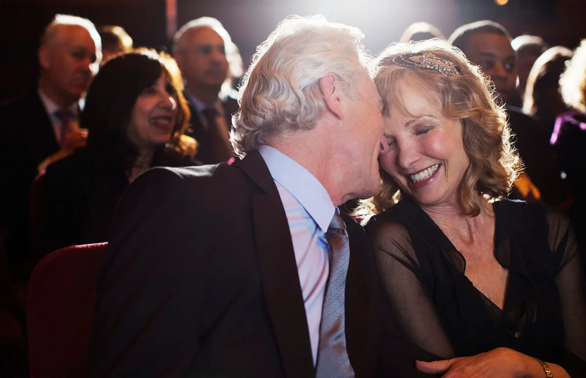 Happy senior couple hugging in theater audience